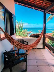 a hammock in a room with a view of the ocean at Chez Max Pousada in Morro de São Paulo