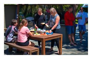 a group of people sitting around a picnic table at Luxury Seaview Apartments in Greymouth