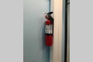 a red fire extinguisher hanging on a door at Fresh Private Apartment Lower level- 2 beds in Brampton