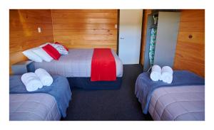 a room with two beds with towels on them at Luxury Seaview Apartments in Greymouth