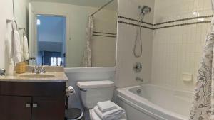 a bathroom with a tub and a toilet and a sink at Comfortable Townhouse in Whistler Village w Hot Tub in Whistler