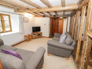 a living room with two chairs and a tv at The Barley Store in Craven Arms