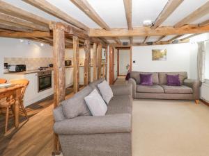 a living room with a couch and a table at The Barley Store in Craven Arms