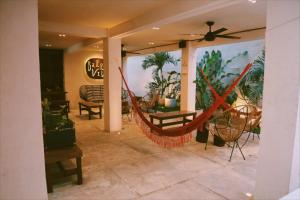 a room with a hammock on a porch with plants at Hostal Barrio Vivo in Mérida