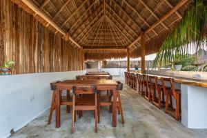 a restaurant with a wooden table and chairs at Kin Ha Tulum Hotel in Tulum