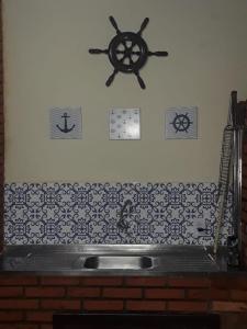 um balcão de cozinha com um lavatório e um relógio na parede em CONDOMÍNIO ILHAS DO JUQUEHY em São Paulo