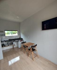 a kitchen with a table and chairs in a room at SUÍTES PRAIA DO ROSA in Imbituba +21 photos