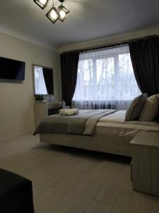ein Schlafzimmer mit einem großen Bett und einem großen Fenster in der Unterkunft VEL Буковина in Czernowitz