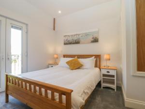 a bedroom with a bed and two lamps and a window at Greenlawns in Burnham on Sea