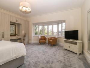 a bedroom with a bed and a desk and a television at Greenlawns in Burnham on Sea