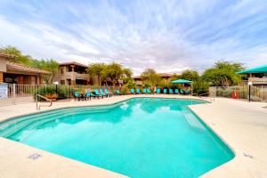 a large swimming pool with blue chairs in a resort at Vistoso Resort Casita #163A in Tortolita