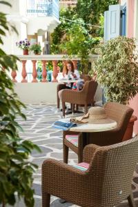 a woman sitting at a table on a patio at 7 Brothers Hotel in Poros