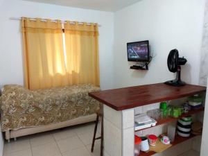 a living room with a couch and a television in a room at Recanto Casa de Pedrinha - Aptos para temporada e finais de semana in Caraguatatuba