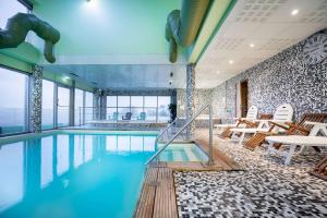 einen Pool in einem Hotel mit Stühlen und Tischen in der Unterkunft Best Western Hotel Ile de France in Château-Thierry