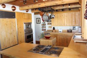 La cuisine est équipée de placards en bois et d'un four avec plaques de cuisson. dans l'établissement Spring Creek Ranch, à Jackson