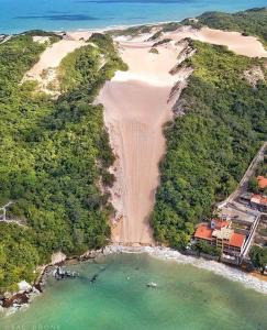 eine Luftansicht auf einen Strand mit einer Wasserfläche in der Unterkunft PontaNegra PontadoSolluciene Apartamento aconchegante Oh Vida Boa in Natal