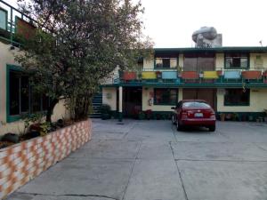 a red car parked in front of a building at Hotel Zaragoza in Puebla