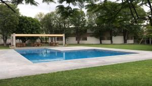 a swimming pool in a yard with a pavilion at Hotel Villablanca in Tehuacán
