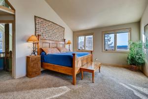 a bedroom with a blue bed and two windows at Four-Bedroom Pineview Haus in Breckenridge
