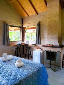 um quarto com uma cama e uma cozinha com janelas em Chalé na Montanha em Santo Antônio do Pinhal