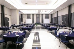 a banquet hall with blue tables and chairs at Harmoni Hotel Garut in Garut