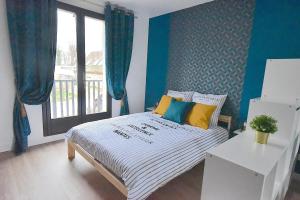 Welcome Home في Vert-le-Grand: غرفة نوم بسرير والجدران الزرقاء ونافذة