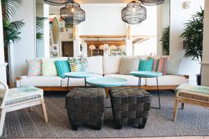 - un salon avec un canapé, des tables et des chaises dans l'établissement Kaimana Beach Hotel, à Honolulu