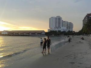 un hombre y una mujer de pie en la playa en Wonderland Private Pool Villas at Port Dickson en Port Dickson