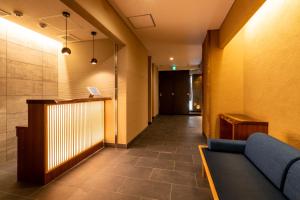 - un couloir avec une salle d'attente dotée d'un canapé bleu dans l'établissement Hotel Iori, à Fukuoka