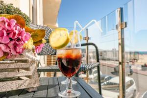 una copa de vino sentada en una mesa en un balcón en Préstige Holidays Alojamentos, en Nazaré