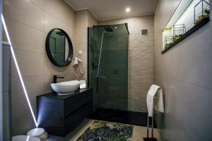 a bathroom with a sink and a shower with a mirror at Préstige Holidays Alojamentos in Nazaré