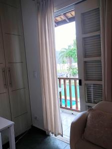a living room with a door open to a balcony at Casa Villaggio Beira-mar in Bertioga