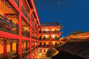 an asian building with a lit up facade at night at Wenjun Courtyard Hotel ---5 mins walk from Tonghuimen metro station, near Tianfu square, close by culture park and Sichuan opera house, English speaking service, local tours in Chengdu