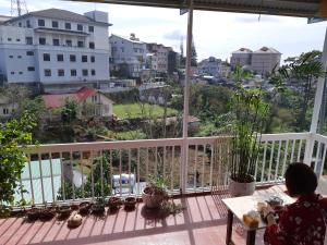 a woman sitting on a balcony looking out at the city at Forelsket 2 in Da Lat