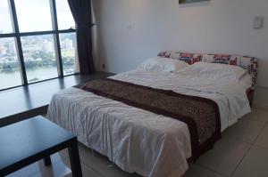 łóżko w pokoju z dużym oknem w obiekcie M City Lake View 1+1 Room w Kuala Lumpur
