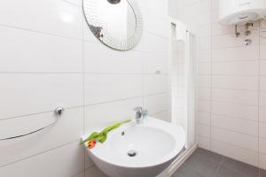Baño blanco con lavabo y espejo en Prior Suites Split, en Split