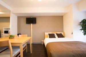 1 dormitorio con 1 cama, escritorio y TV en ようこそ札幌へ! 大通公園まで地下鉄10分 定員6名 fireTV完備 1階はセコマ en Sapporo