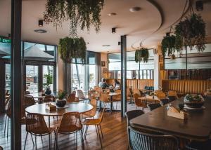 un restaurante con mesas, sillas y ventanas en Shoreline Hotel, en Hobart