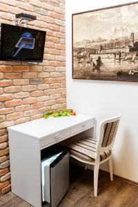 a white desk with a chair next to a brick wall at Prior Suites Split in Split