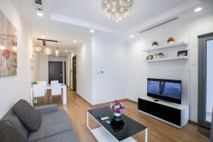 Una sala de estar con un sofá y un televisor en BOM HOMES- VINHOMES TIMES CITY & PARK hilll, en Hanói