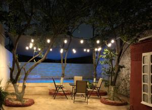 梅里达Casa Lool Beh的天井配有桌椅,灯光下