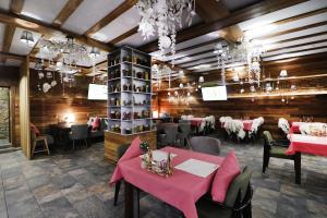 ベロクリハにあるSpa Resort Kedroviyのピンクのテーブルと椅子、シャンデリアが備わるダイニングルーム