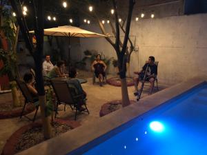 un groupe de personnes assises autour d'une piscine dans l'établissement Casa Lool Beh, à Mérida
