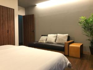 Teruya的住宿－D-and Stay HH.Y Resort Okinawa，一间卧室配有一张床和一张沙发