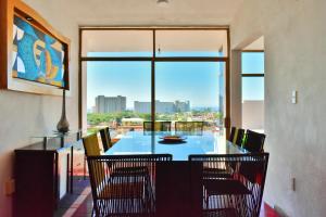 une salle à manger avec une table, des chaises et une grande fenêtre dans l'établissement Hotel Blue Home Vallarta, à Puerto Vallarta