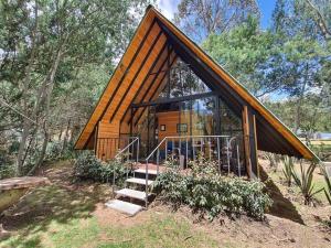 a small cabin in the middle of a forest at Glamping Los Ángeles in Guasca