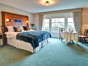 a bedroom with a large bed and a table in it at Bay Villa in Grange Over Sands