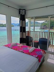 a bedroom with a bed with a view of the water at Mr. Bean Resort in Sabang