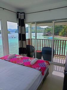 a bedroom with a bed with a view of the water at Mr. Bean Resort in Sabong