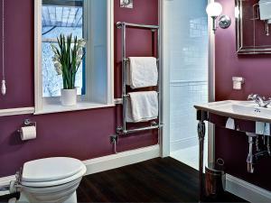 a purple bathroom with a toilet and a sink at Bay Villa in Grange Over Sands